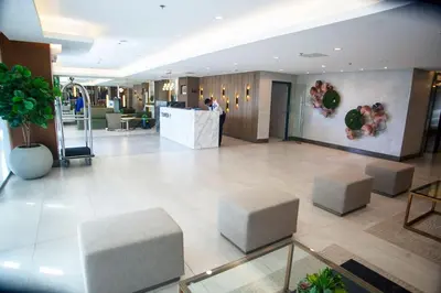 a lobby with stools and a counter in a building at Furnished Condo Unit-Green2 PoolWifiNetflix in Dasmariñas