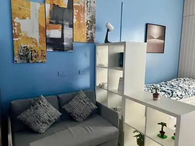 a living room with a couch and a bed at Condo Near World Trade, Star City and PICC - Amazing Breeze in Manila