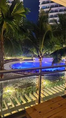 a view from the balcony of a resort with a palm tree at azure 1bedroom pool view in Manila