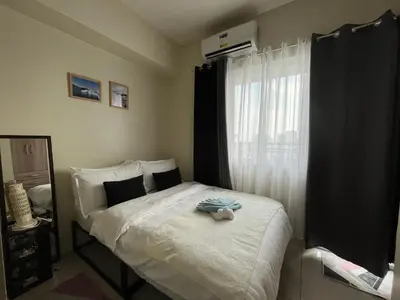 a bedroom with a bed with a towel on it at Breeze Residences pasay near naia airport in Manila