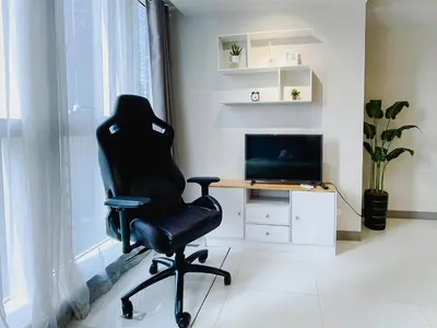 a black chair in a room with a desk and a television at 1 BR Cozy unit Uptown Parksuites BGC in Manila