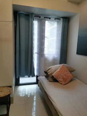 a bedroom with a bed with a window and a pillow at Mall of Asia residence Shore 3 in Manila