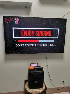 a sign hanging on a wall with a sign that says enjoy singing dont forget to at Mall of Asia residence Shore 3 in Manila