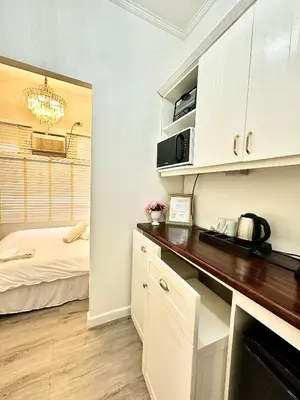 a kitchen with a counter with a microwave and a bed at Studio Two Condominium - Olive in Manila