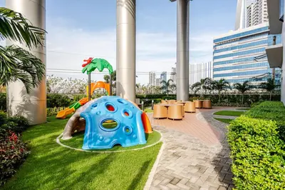 a playground in a resort with a slide at Relaxing 1BR condo with Pool and Balcony in Makati in Manila