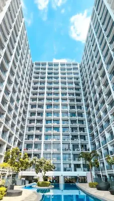 a large building with a pool in front of it at MOA Staycation at Shore 2 Residences Tower 1 in Manila