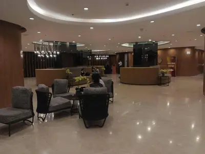 a person sitting at a table in a lobby at Peaceful Pasay Getaway - Private Studio with Pool in Manila