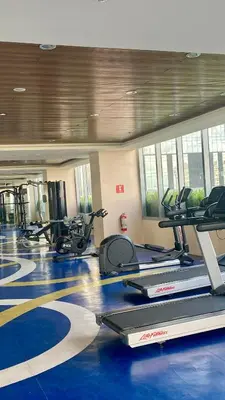 a gym with several treadmills and elliptical machines at Grand View Tower Queen Bed Modern Condo in Manila