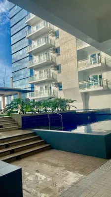 a building with a swimming pool in front of a building at Grand View Tower Queen Bed Modern Condo in Manila