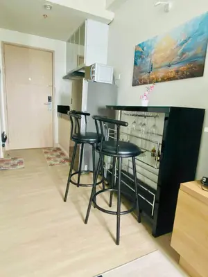 a kitchen with three bar stools in front of a counter at SMDC Park Residences Condo Unit 417 near SM City Sta Rosa in Ibaba