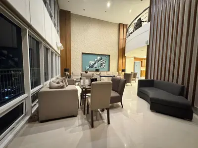 a living room with a dining table and chairs at Bay View near US Embassy, Airport in Manila