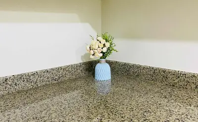 a blue vase with flowers in it sitting on a counter at V-TAN house in Manila