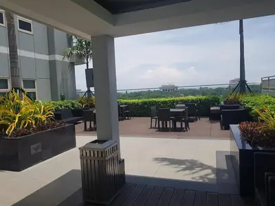 a patio with tables and chairs on a building at Cozy Coast Residences Pasay in Manila