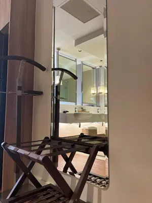 a mirror reflecting a chair in front of a bathroom at The hotel residences at Acqua in Manila