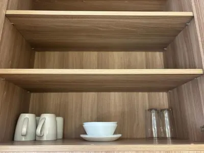 a wooden shelf with bowls and vases on it at The hotel residences at Acqua in Manila