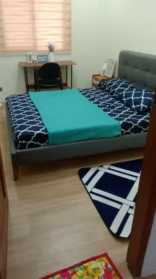 a bedroom with a bed and a desk with a phone at CASA CORAZON Spacious 4BR House Near Tagaytay for Wedding Prep Family Gatherings Reunions and Celebrations Pet Friendly and PWD Accessible in Dagatan
