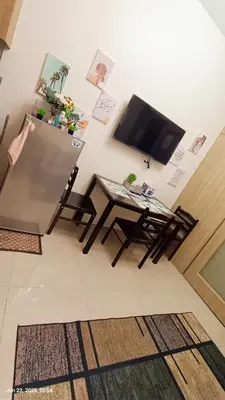 a living room with a television and a table at Shore Residences Tower D # 408 in Manila