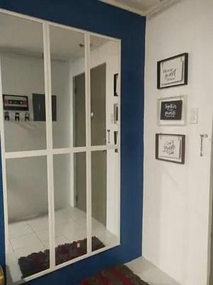 a room with a large mirror on a blue wall at El Cozy Woody Near Enchanted Kingdom in Santa Rosa