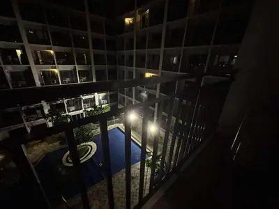 a view from a balcony of a building at night at Entire 1 BR condo unit with balcony at MOA complex in Manila