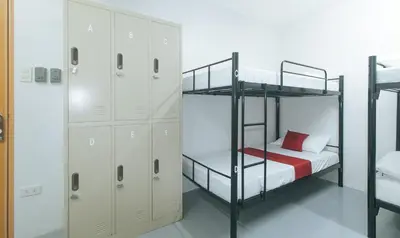 a bedroom with two bunk beds and a locker at RedDoorz at Qhouzz near PUP in Manila