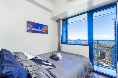 a bedroom with a bed and a large window at 1BR Staycation at AIR Residences Makati City in Manila
