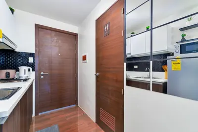 a kitchen with a wooden door and a sink at 1BR Staycation at AIR Residences Makati City in Manila