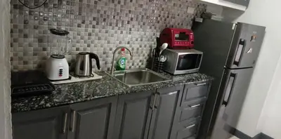 a kitchen counter with a sink and a microwave at Birch Tower - 1BR with balcony in Manila