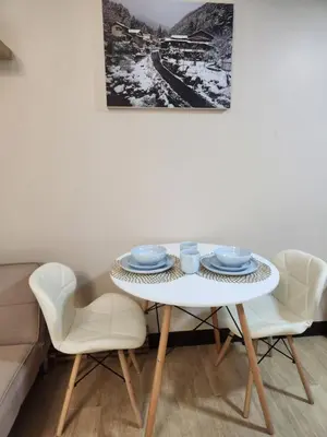 a white table with two chairs and blue dishes on it at Staycation By JEM - Across NAIA T3 in Newport City in Manila