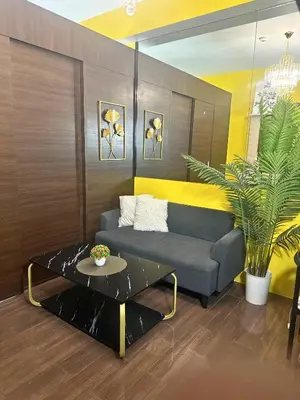 a living room with a couch and a table at Air Residences- Netflix with City View in Manila