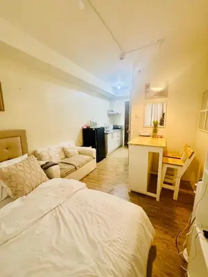 a living room with a bed and a kitchen at Berkeley Breeze Staycation in Silang