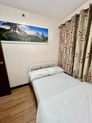 a bedroom with two beds and a painting on the wall at Arista Place 2 bedroom Condo near airport in Manila