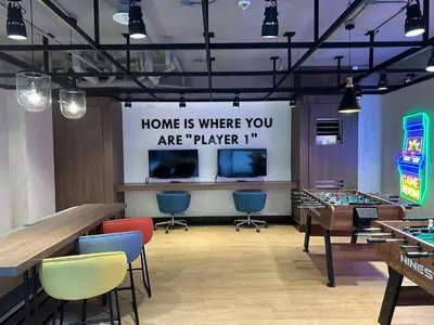 a game room with tables and chairs and avertisement at Airport Home Base Trips Getaways 3pax balcony 6g in Manila