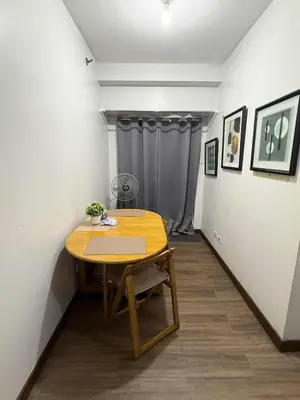 a wooden table in a room with a curtain at LA VERTI 1B MINIMALIST AFFORDABLE STAYCATION IN PASAy in Manila