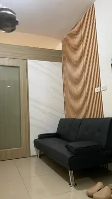 a black couch sitting in a room with a door at Scarlet Stay in Manila
