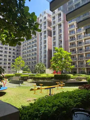 a park with picnic tables and large buildings at Bayhaus MNL - Pet-friendly Condo near MOA in Manila