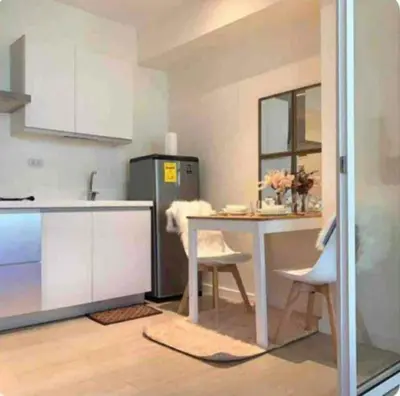 a kitchen with a table and a refrigerator at Natalie Staycation Buddies in Manila