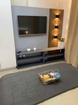 a living room with a television and a basket on a rug at Natalie Staycation Buddies in Manila