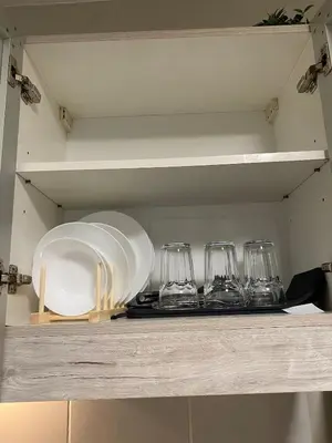a shelf with wine glasses and plates on it at BayHaus MNL - Pet-friendly Condo Near MOA in Manila