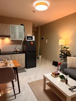 a living room with a couch and a kitchen at BayHaus MNL - Pet-friendly Condo Near MOA in Manila