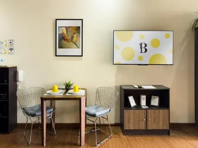 a room with a table and chairs and a picture at Place in Century Poblacion in Manila