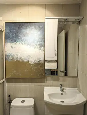 a bathroom with a sink and a painting above a toilet at BBricks Alabang Beside Festival Mall in Manila