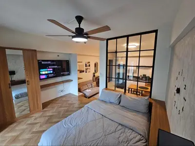 a bedroom with a bed and a ceiling fan at Affordable Condo Suite with WIFI in McKinley BGC in Manila