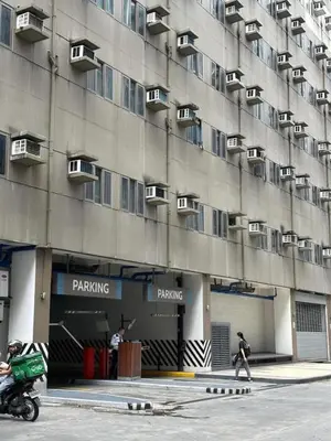 a man riding a motorcycle in front of a building at DS Staycation in Manila