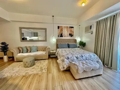 a large bedroom with a bed and a couch at Modern Condo at The Venice Luxury Mckinley Hill in Manila