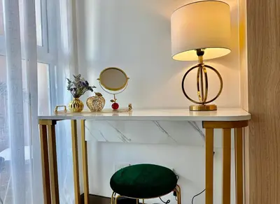 a table with a lamp and a green stool at Modern Condo at The Venice Luxury Mckinley Hill in Manila