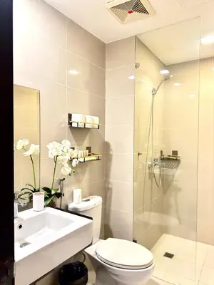a bathroom with a toilet and a sink and a shower at Modern Condo at The Venice Luxury Mckinley Hill in Manila