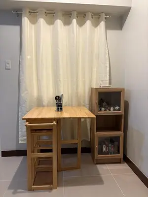 a wooden table in a room with a curtain at Modern 2BR Condo with Balcony in Central Manila in Manila