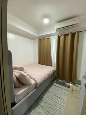 a small bedroom with a bed and a window at Shore Staycation in Manila
