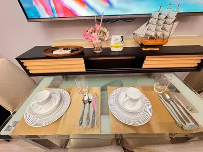 a glass table with plates and utensils on it at Shore Staycation in Manila