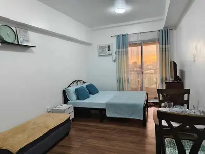 a small bedroom with a bed and a window at Windsong Suite Unli Netflix Disney Roofdeck View in Manila